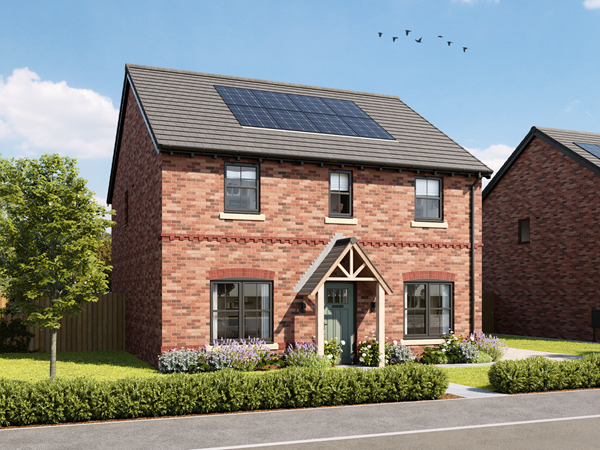 A red brick new build home by Charles Church, with green grass and a blue sky.
