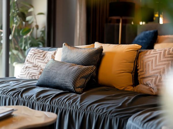 A modern sofa with lots of textured pillows. 