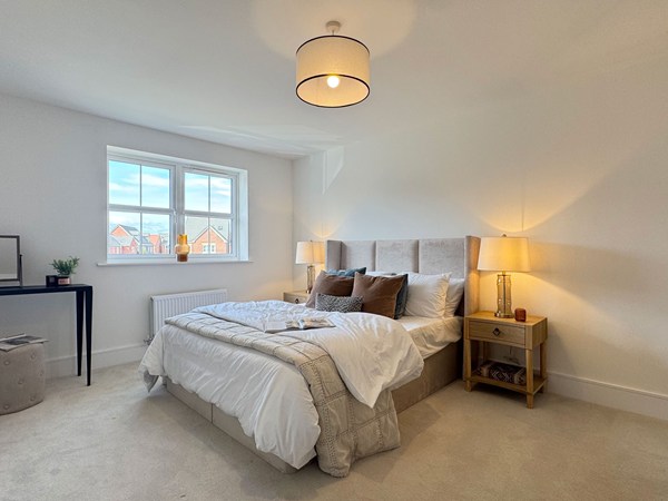 Double bedroom with neutral décor, bedside tables and window