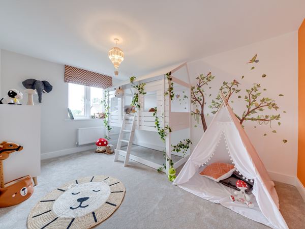 A bright and modern child's bedroom in a Charles Church home, with a tipi and tree wall mural. 
