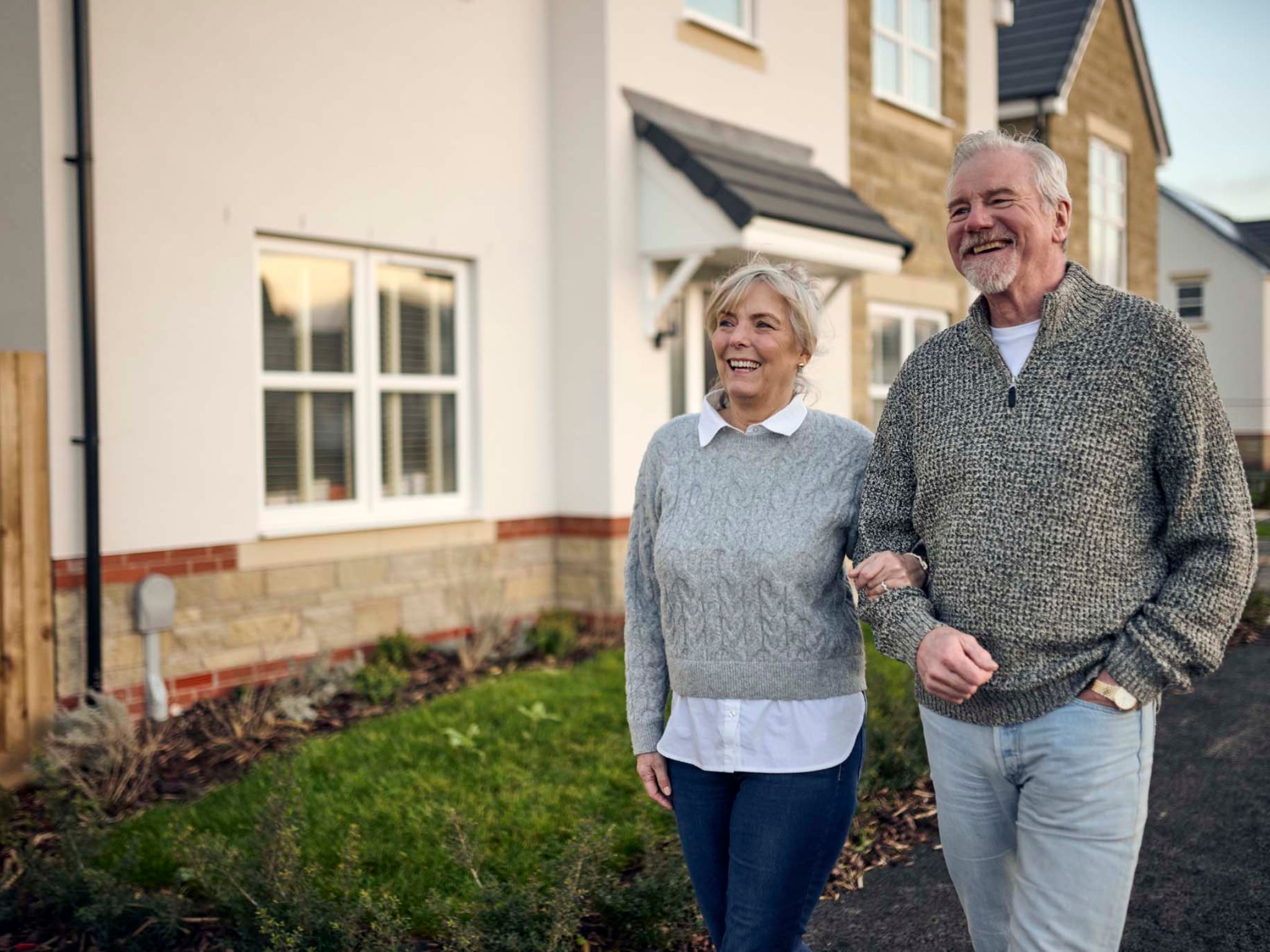A man and a woman walking down a Charles Church street.