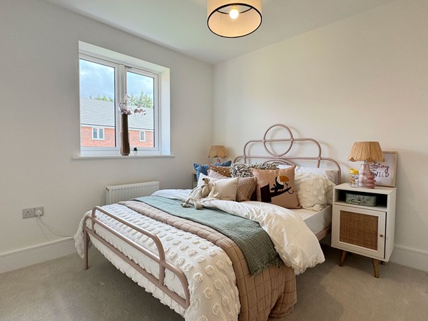 Bedroom with styled bed, bedside table and large window