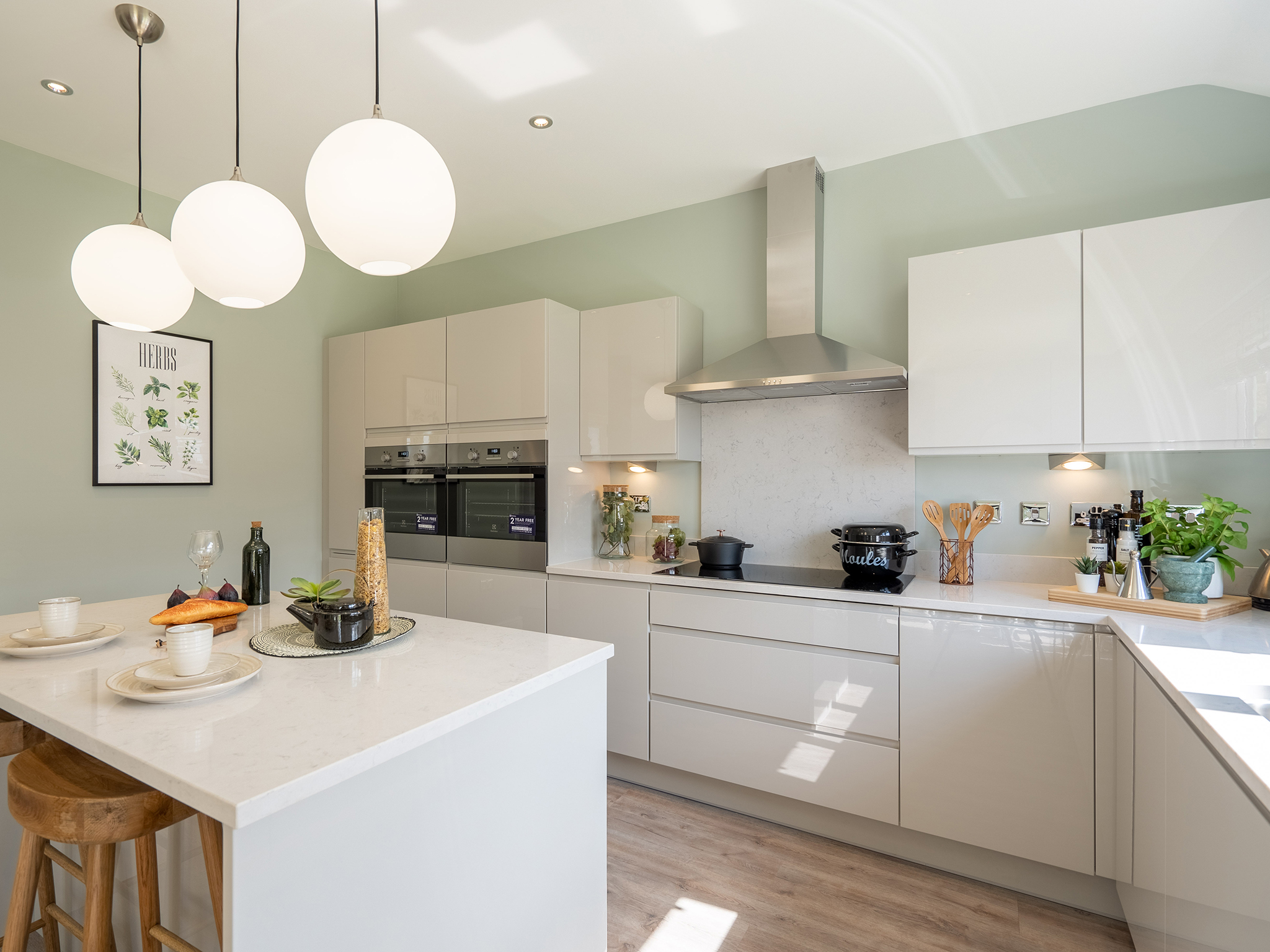 An interior shot of a bright, modern, spacious kitchen with grey gloss units in a premium new home by Charles Church.