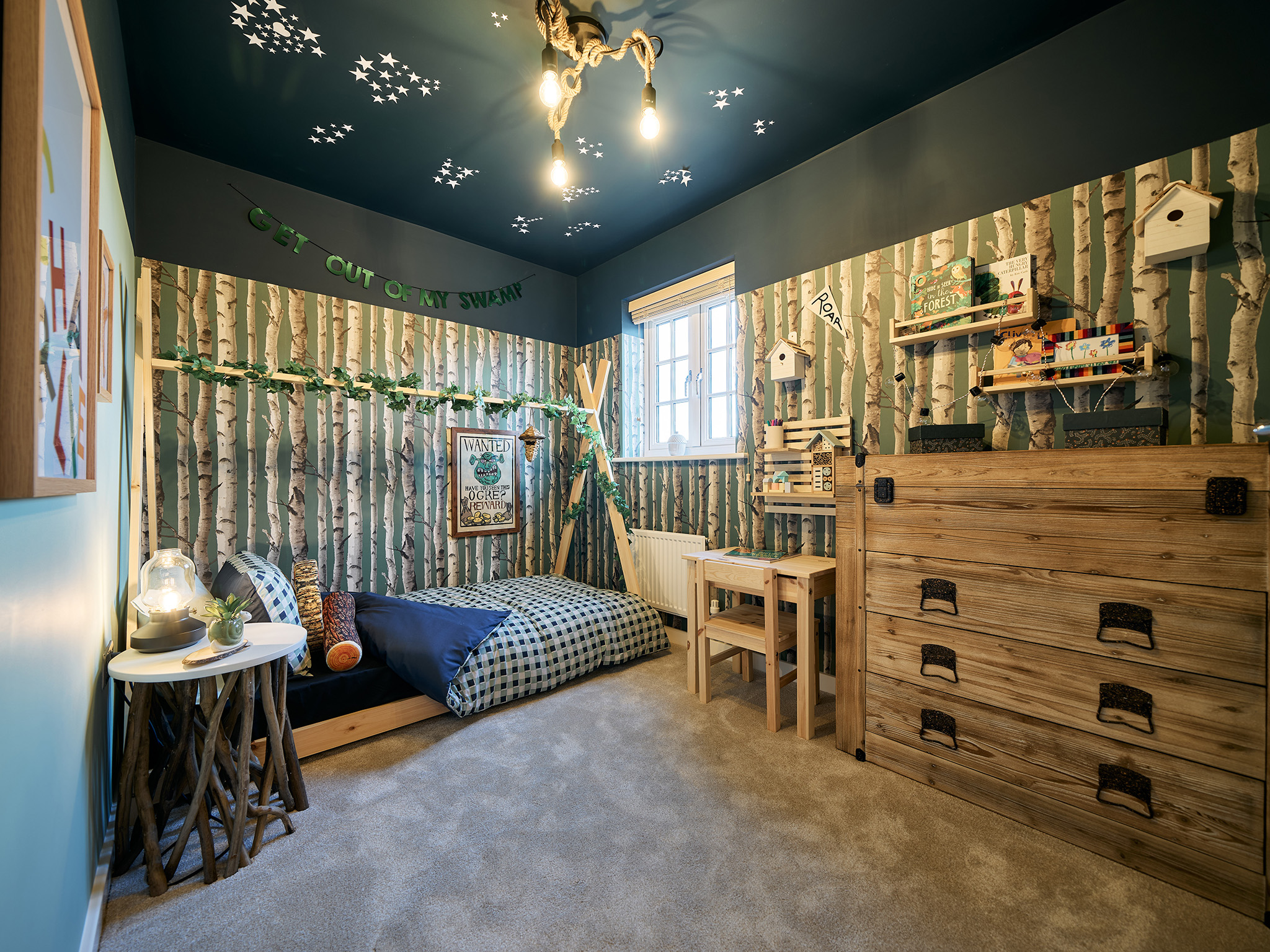 Forest themed child's bedroom with wooden dresser and shelves