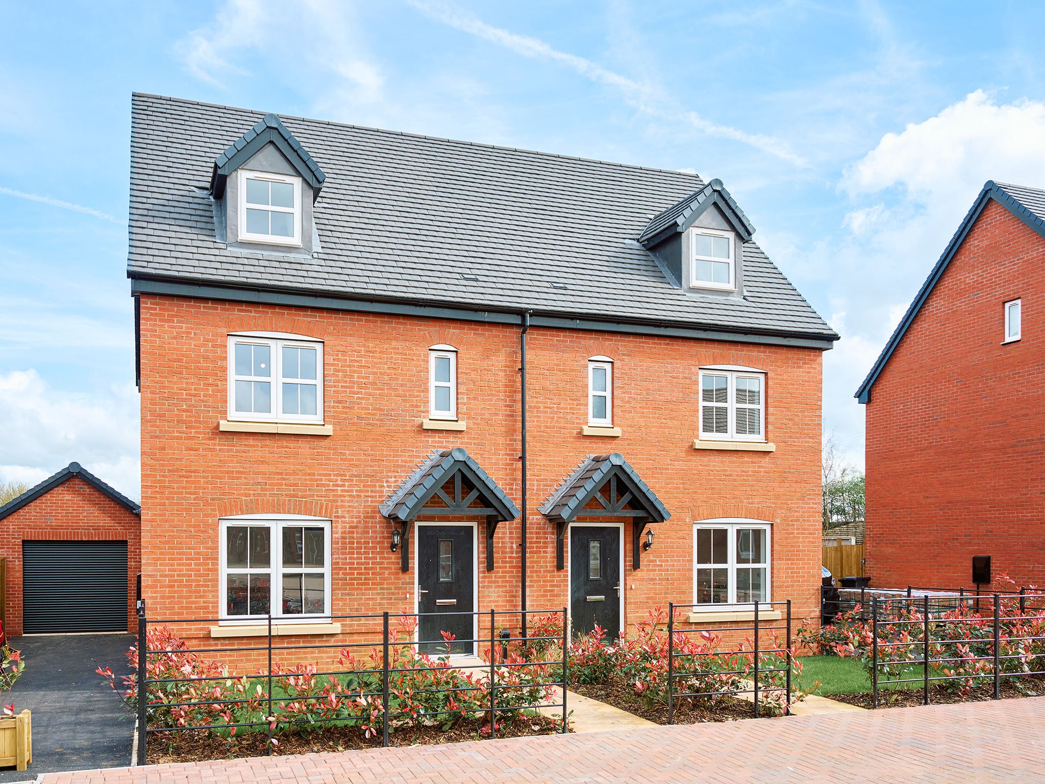 Two semi detached red brick new build houses