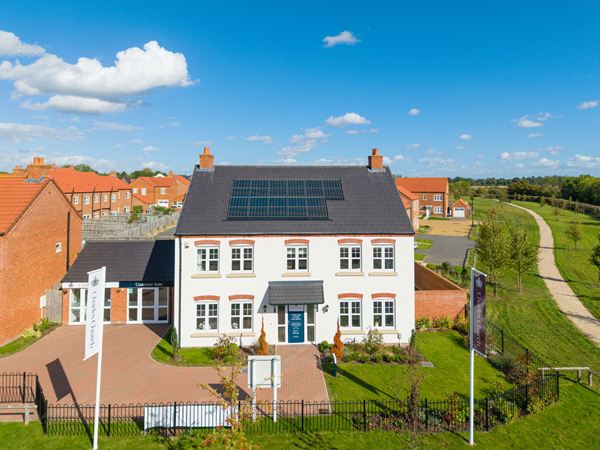 Aerial view of modern new build homes beside open countryside