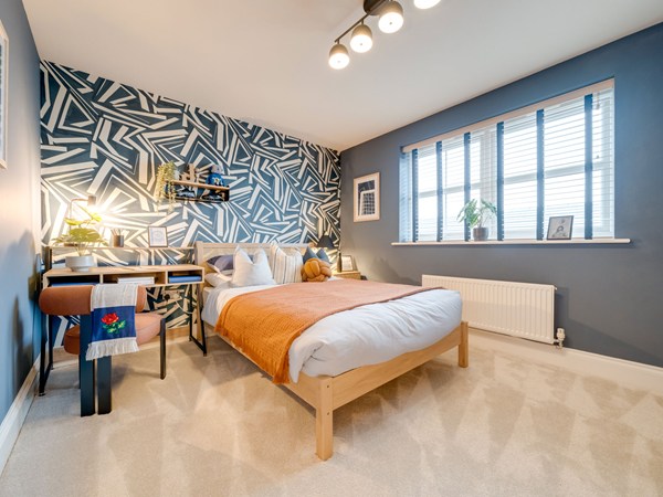 Bedroom with geometric wallpaper and study desk at Heysham development.