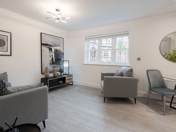Bright living room with modern furniture and large windows in a new build home.