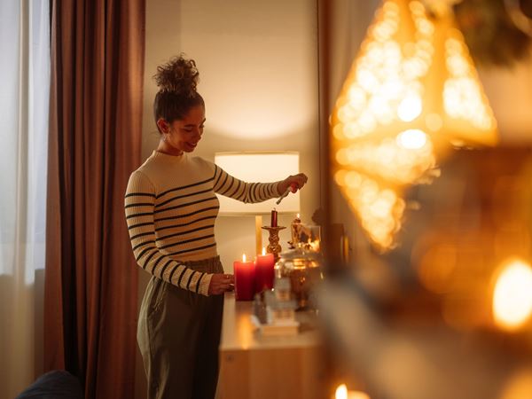 A woman lighting candles in a modern home. 