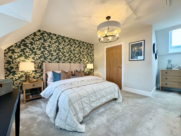 Main bedroom in the Brindle new build home with feature wallpaper and sloped ceiling.