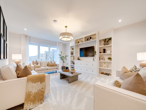 Living room with cream sofas and built-in shelving at Heysham new build.