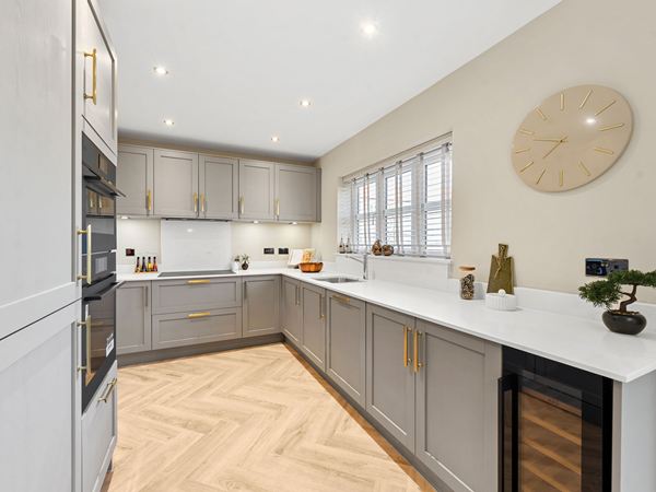 Modern kitchen with grey cabinetry, white worktops and herringbone flooring