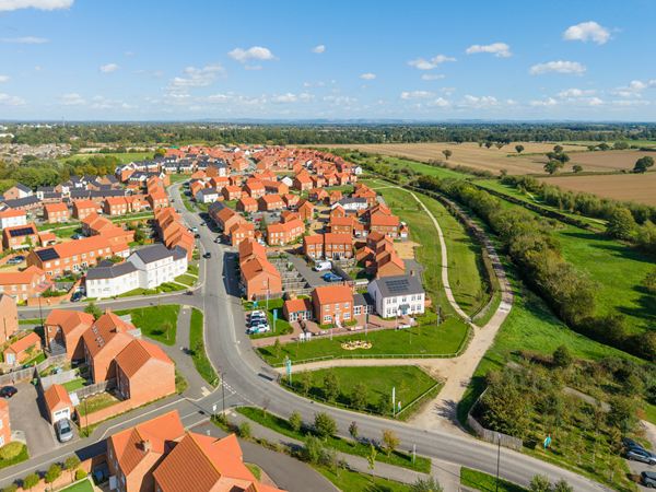 Aerial view of new build development surrounded by green countryside