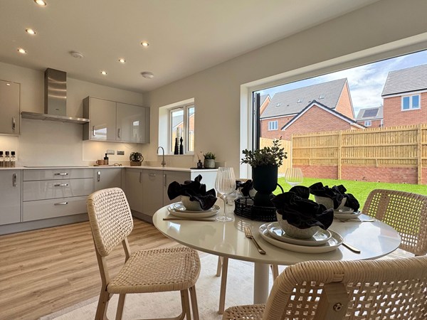 Kitchen dining area with garden views through open doors