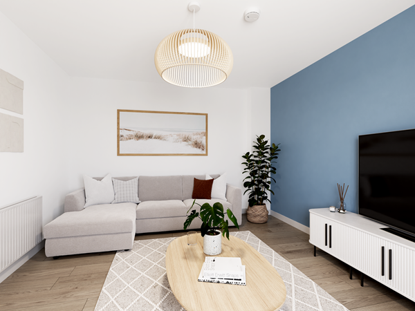 Bright living room with a blue feature wall, a light gray L-shaped sofa, and a wooden coffee table on a patterned rug. A large flat-screen TV sits on a white media unit, and a potted plant adds greenery. A woven pendant light hangs from the ceiling.