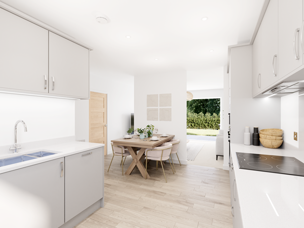 Bright kitchen with light grey cabinets, white worktops, induction hob and view into dining area with wooden table.