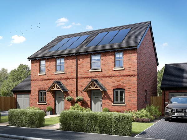 emi-detached two-bedroom homes with red brick exteriors, pitched grey tiled roofs, and decorative porch canopies. Each home features two front-facing windows on the upper floor and a landscaped front garden with shrubs and a small tree, set along a quiet residential street under a bright blue sky.
