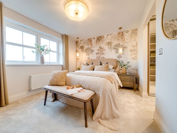Master bedroom with botanical wallpaper and upholstered bed at Heysham development.