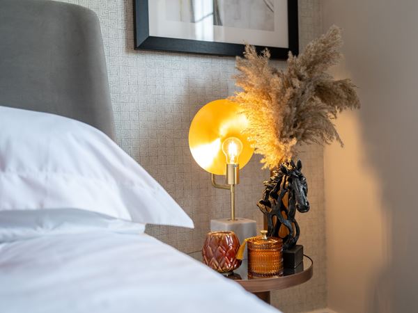 A lamp and a vase on a bedside table in a modern Charles Church home. 