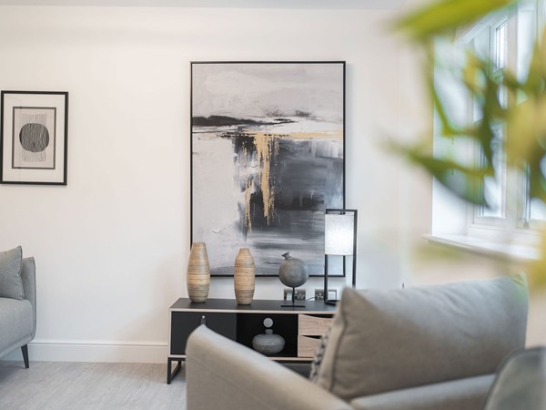 Bright open-plan living room with modern seating and large windows.