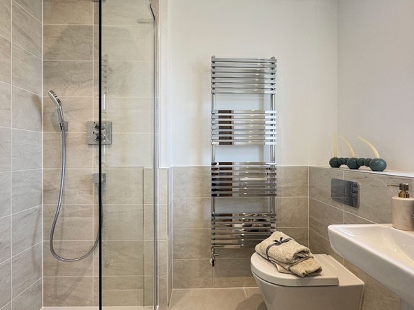 Shower room with tiled enclosure, toilet and heated towel rail