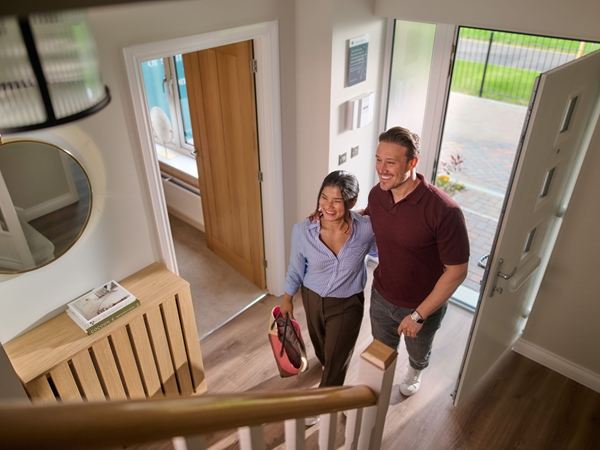 A man and a woman entering a new build home by Charles Church, smiling 