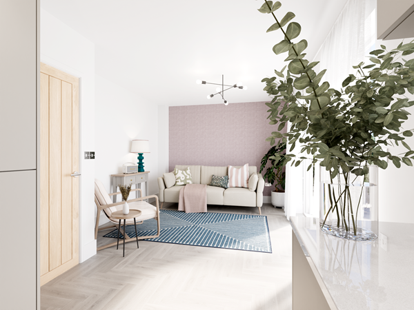 Open-plan kitchen and family area with a light wood door, a white countertop, and a glass vase with greenery in the foreground. A cozy seating area with a cream sofa and pink accent wall is visible in the background, complemented by a patterned blue rug and modern lighting.
