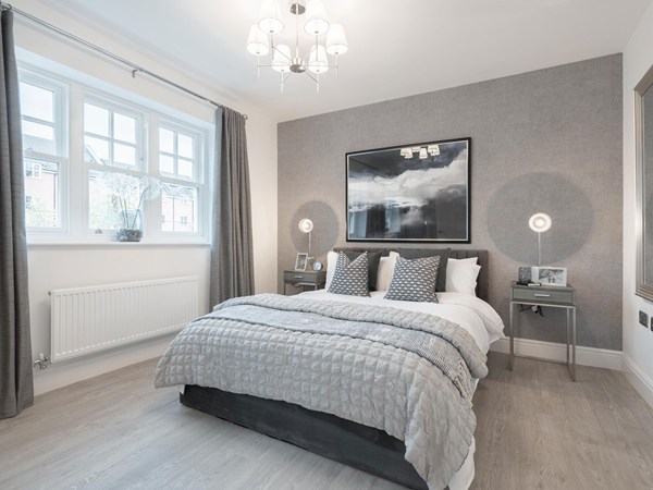 Contemporary double bedroom with feature wall and large windows in a new build home.