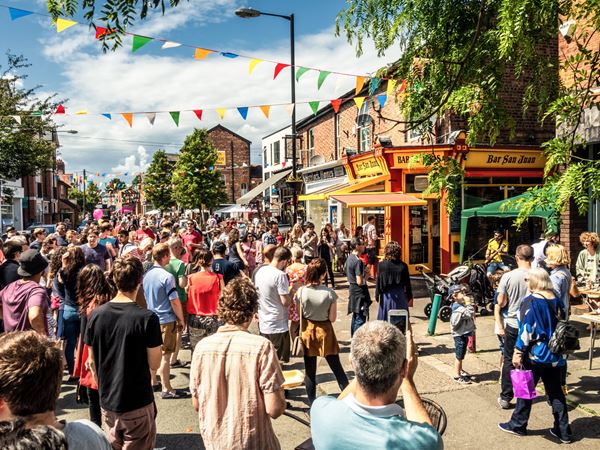A lively community event on a summer day in a small town with bunting.