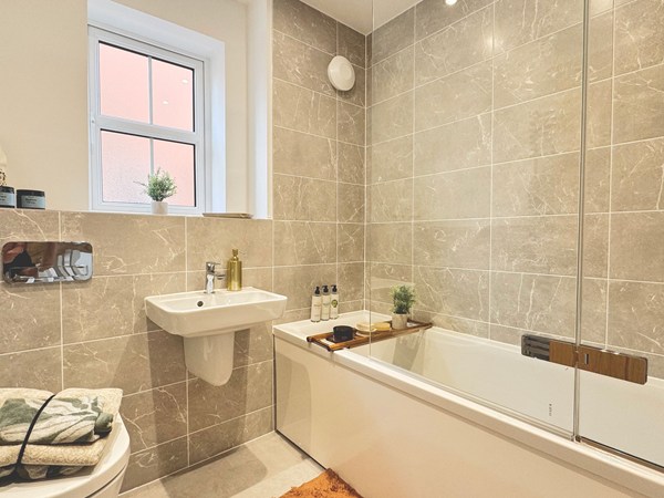 Bathroom with bath, glass screen, basin and tiled walls